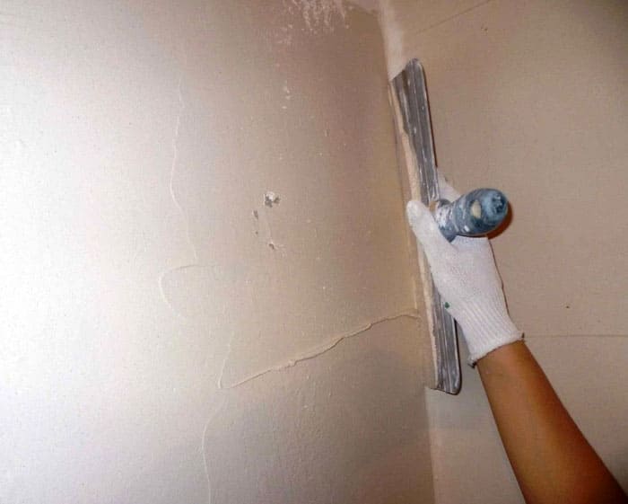 An den Wänden sind Unregelmäßigkeiten vorhanden, und die geklebte Tapete zeigt diesen Defekt perfekt.