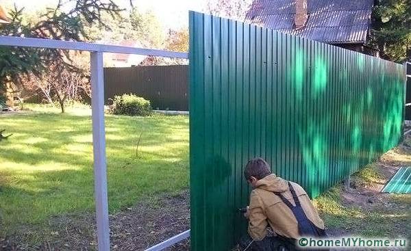 Selbstschneidende Schrauben, die der Farbe der Wellpappe entsprechen, sind am Zaun praktisch unsichtbar