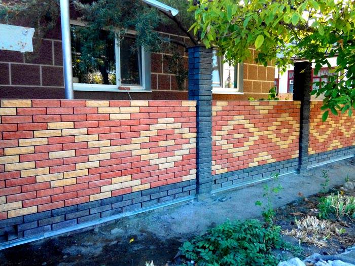 Die Verwendung von dekorativen Ziegeln in Zäunen sieht gut aus. Es kann verwendet werden, um echte Mosaikmuster zu erstellen