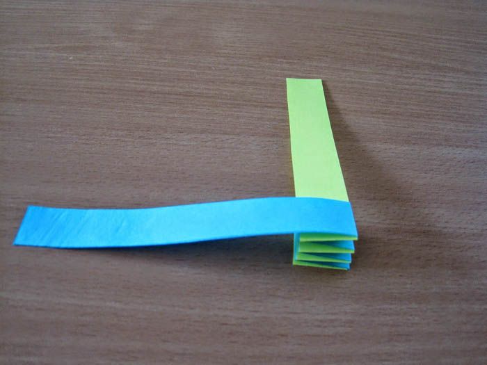 Bierzemy dwa wąskie i długie paski i nakładamy je końcówkami prostopadłymi do siebie. Końce przyklejamy PVA. Zaczynamy zginać paski jeden na drugim. Jak tylko pasek się skończy, przyklejamy do niego nowy