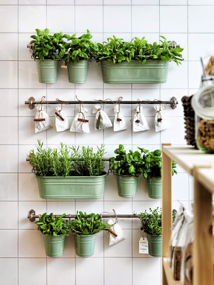 Mini potter med kunstige planter har det godt ved siden af forklædet. Et sådant tilbehør fortynder det monotone forklæde betydeligt.