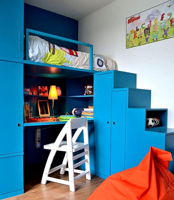 El rincón para niños debe diseñarse en un esquema de color adecuado y estar equipado con un conveniente sistema de almacenamiento. La cama se coloca lo más convenientemente posible para todos los miembros de la familia